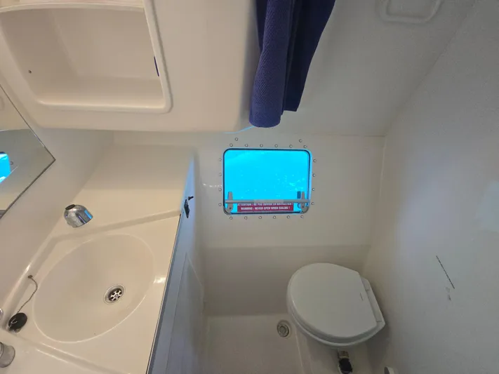Think Twice Yacht Photos Pics Bathroom interior of 2005 Fountaine Pajot Lavezzi Maestro catamaran with sink, toilet, and window.
