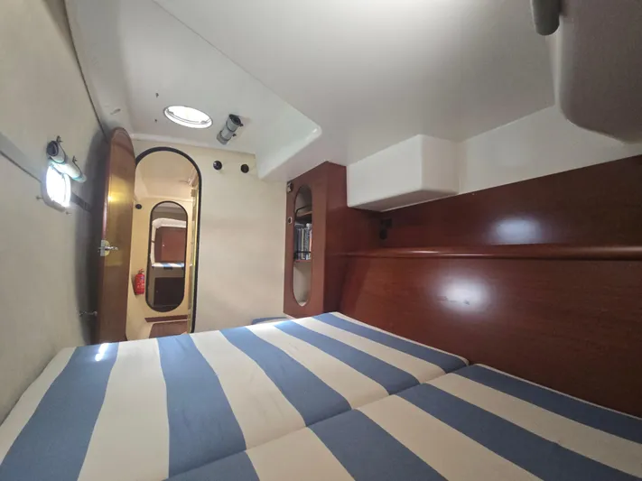 Think Twice Yacht Photos Pics 2005 Fountaine Pajot Lavezzi Maestro cabin with striped bedding and wooden interior.