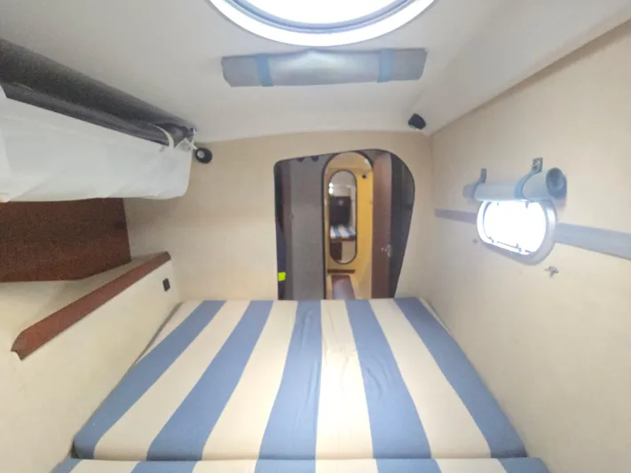 Think Twice Yacht Photos Pics 2005 Fountaine Pajot Lavezzi Maestro cabin interior with striped bedding and porthole window.