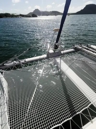 Think Twice Yacht Photos Pics 2005 Fountaine Pajot Lavezzi Maestro catamaran on water, featuring netted deck and scenic background.