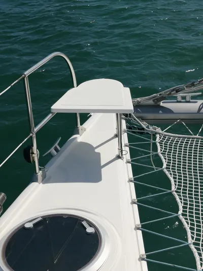 Think Twice Yacht Photos Pics 2005 Fountaine Pajot Lavezzi Maestro catamaran deck with netting over blue water.