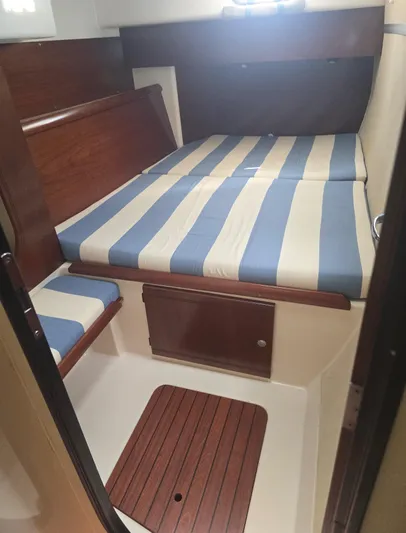 Think Twice Yacht Photos Pics 2005 Fountaine Pajot Lavezzi Maestro cabin with striped bedding and wooden accents.