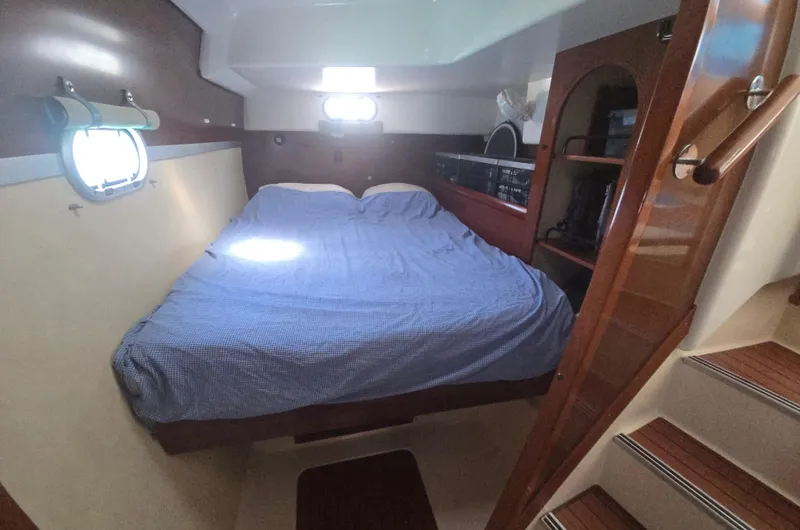 Think Twice Yacht Photos Pics 2005 Fountaine Pajot Lavezzi Maestro cabin with double bed, wooden interior, and porthole window.