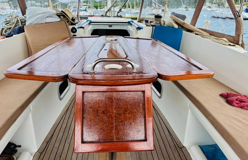 Magique 2 Yacht Photos Pics 2005 Beneteau Oceanis 523 cockpit with wooden table and seating, docked in a marina.