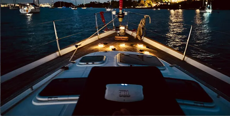 Magique 2 Yacht Photos Pics Beneteau Oceanis 523 sailboat at night, illuminated deck, calm waters, 2005 model.