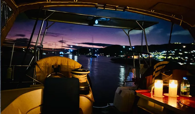 Magique 2 Yacht Photos Pics 2005 Beneteau Oceanis 523 sailboat at sunset, with candles and scenic harbor view.