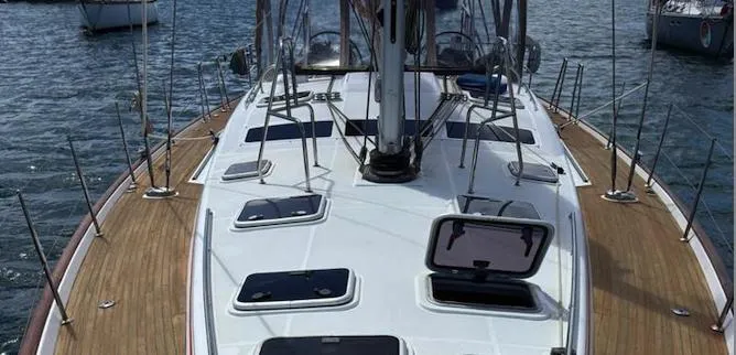 Magique 2 Yacht Photos Pics 2005 Beneteau Oceanis 523 sailboat deck with open hatches on calm water.