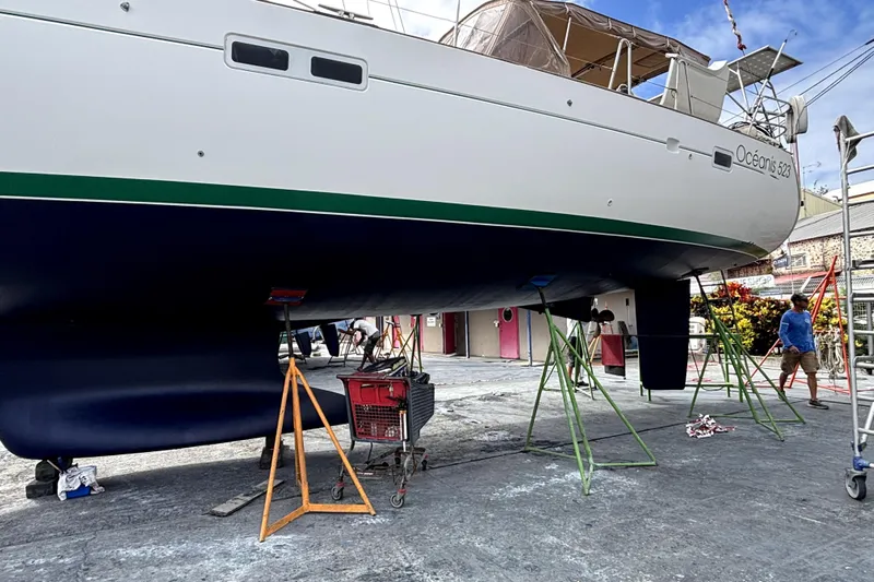 Magique 2 Yacht Photos Pics 2005 Beneteau Oceanis 523 sailboat on dry dock for maintenance, supported by stands.