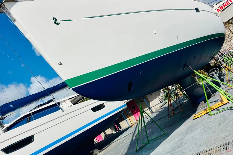 Magique 2 Yacht Photos Pics Beneteau Oceanis 523 sailboat, 2005 model, on dry dock with vibrant blue and green hull.