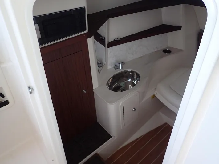 Yacht Photos Pics 2021 Grady-White Freedom 325 boat interior with sink and wooden cabinetry.