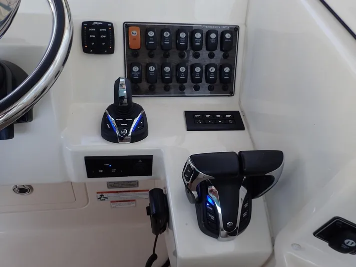  Yacht Photos Pics Control panel of 2021 Grady-White Freedom 325 boat with steering and throttle controls.