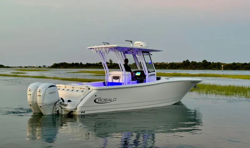  Yacht Photos Pics 2024 Robalo R270 Center Console boat on calm water at sunset.