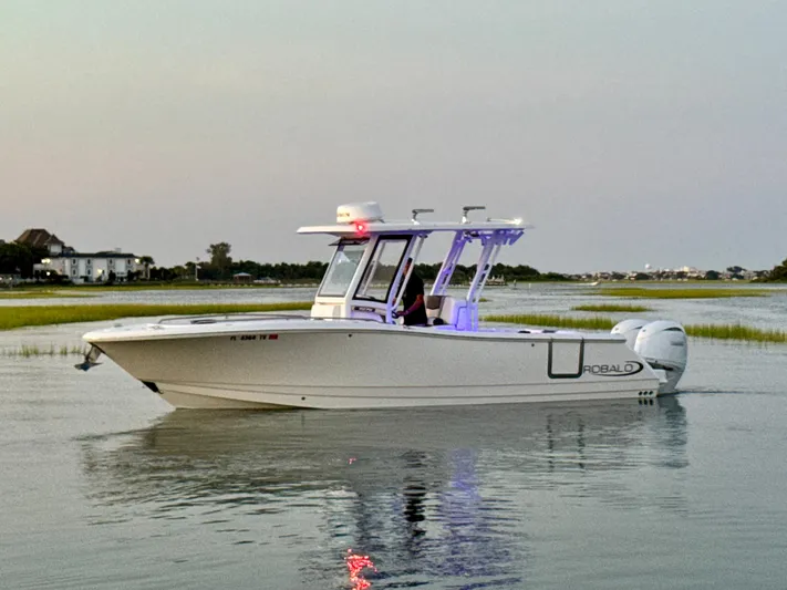  Yacht Photos Pics 2024 Robalo R270 Center Console boat on calm water at sunset.