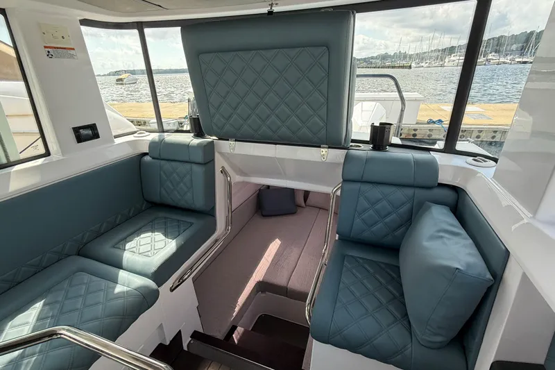 Maverick Yacht Photos Pics Luxurious interior of 2023 Axopar 37 XC AFT CABIN with quilted seating and waterfront view.