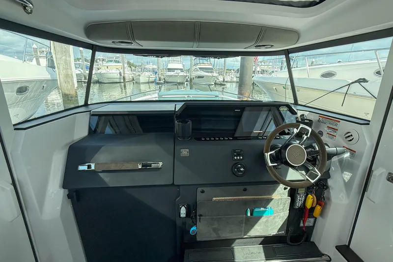 Maverick Yacht Photos Pics Interior view of 2023 Axopar 37 XC AFT CABIN boat cockpit with steering wheel.