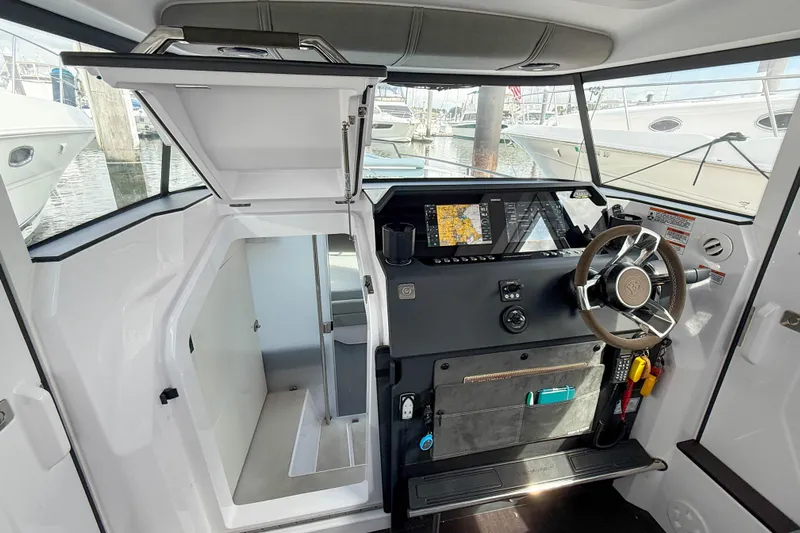 Maverick Yacht Photos Pics 2023 Axopar 37 XC AFT CABIN helm with modern navigation system and steering wheel.