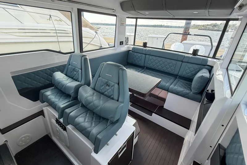 Maverick Yacht Photos Pics Luxurious interior of 2023 Axopar 37 XC AFT CABIN with plush seating and panoramic windows.