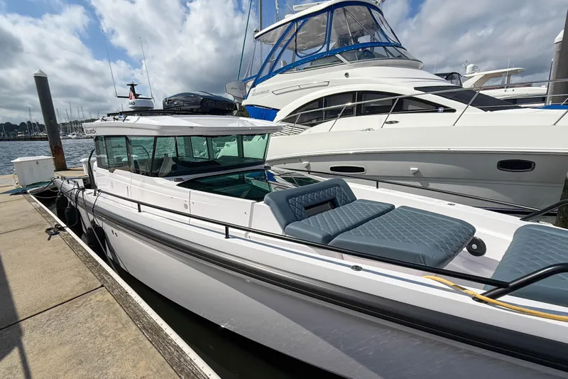 Maverick Yacht Photos Pics 2023 Axopar 37 XC AFT CABIN docked at marina, featuring sleek design and spacious seating.