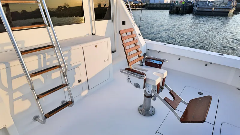  Yacht Photos Pics 1998 Viking 47 Convertible yacht deck with fishing chair and ladder by the water.