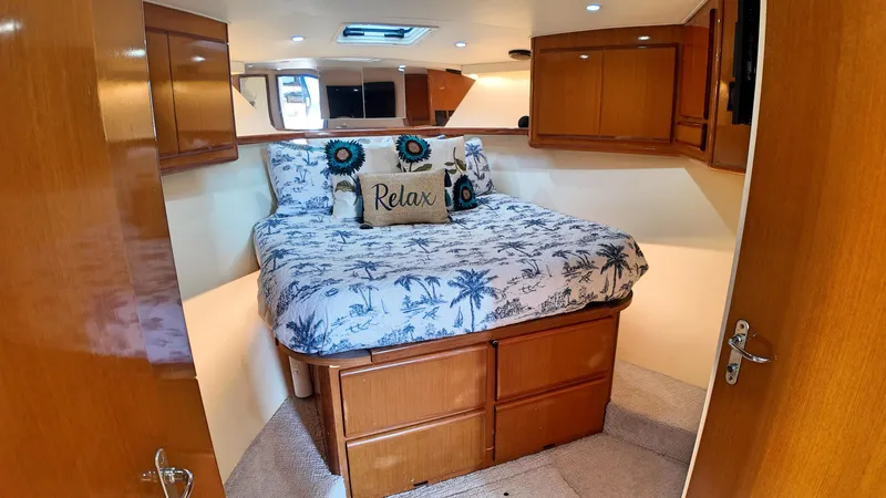  Yacht Photos Pics Interior of 1998 Viking 47 Convertible yacht with cozy bedroom and wooden cabinetry.