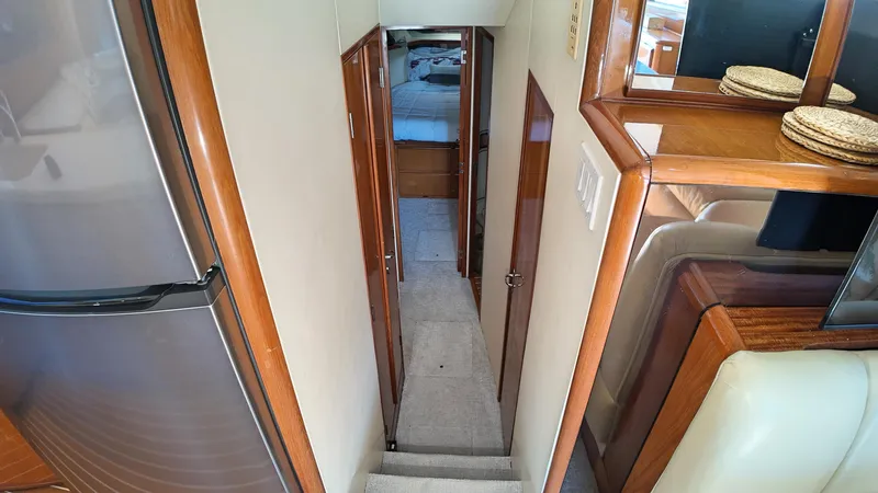  Yacht Photos Pics Interior hallway of a 1998 Viking 47 Convertible yacht, featuring wood accents and carpeted flooring.
