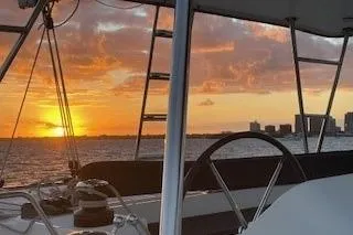  Yacht Photos Pics 2019 Lagoon 450 sailing at sunset with city skyline in the background.