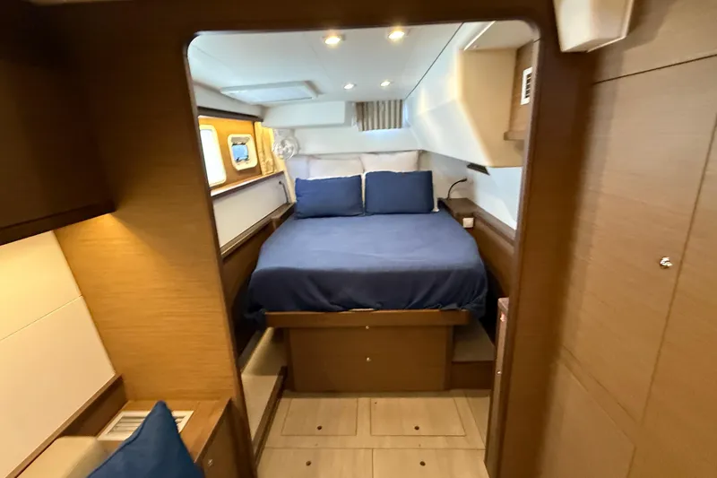  Yacht Photos Pics Luxurious cabin interior of 2019 Lagoon 450 yacht with cozy bed and wooden furnishings.