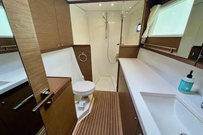  Yacht Photos Pics Luxurious bathroom in 2019 Lagoon 450 yacht with modern fixtures and wooden accents.
