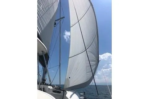  Yacht Photos Pics 2019 Lagoon 450 sailboat with sails unfurled against a clear blue sky.