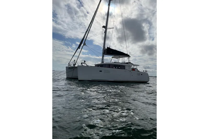  Yacht Photos Pics 2019 Lagoon 450F catamaran sailing on open water under a cloudy sky.