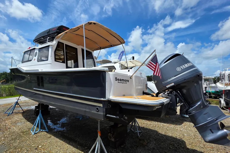 Seamore Yacht Photos Pics 2020 Ranger Tugs R27LE boat on stands, Yamaha engine, American flag, clear sky.