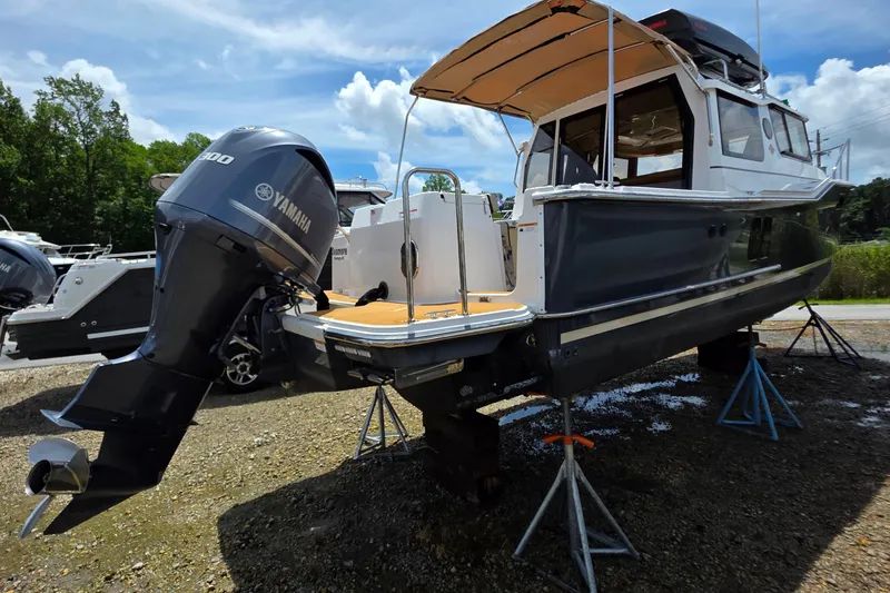 Seamore Yacht Photos Pics 2020 Ranger Tugs R27LE boat with Yamaha engine on stands, outdoor setting.