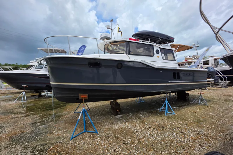 Seamore Yacht Photos Pics 2020 Ranger Tugs R27LE boat on stands, displayed outdoors under cloudy sky.