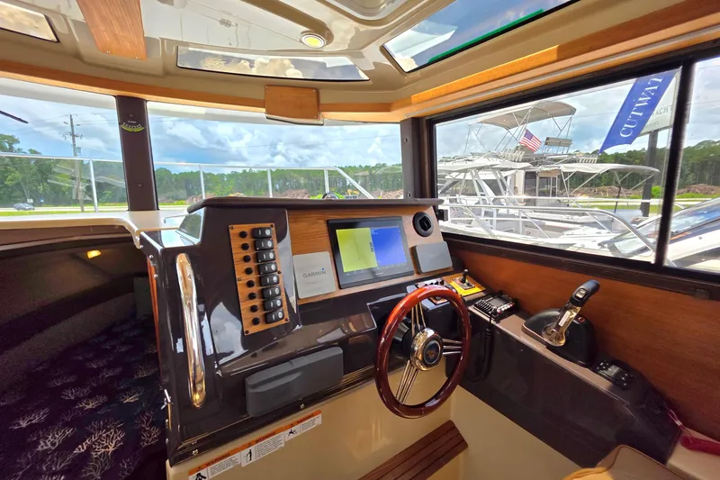 Seamore Yacht Photos Pics 2020 Ranger Tugs R27LE helm with navigation system and wooden steering wheel.