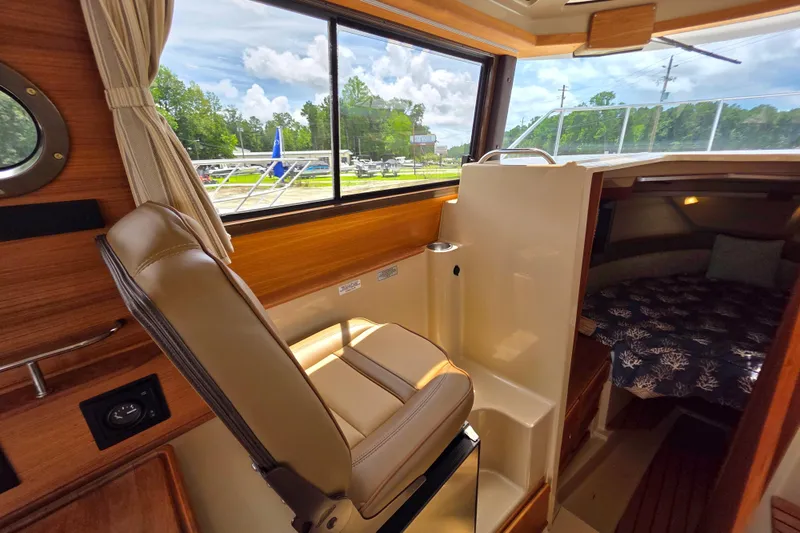 Seamore Yacht Photos Pics Interior of 2020 Ranger Tugs R27LE boat with helm seat and cozy cabin.