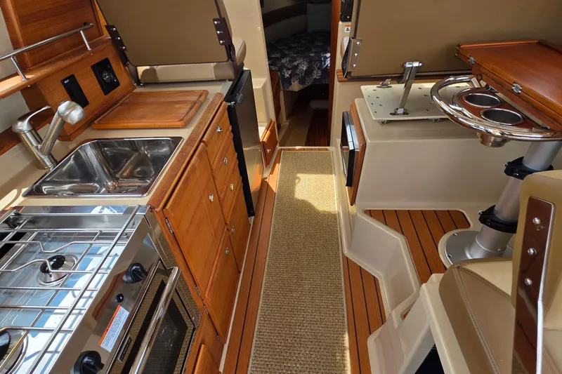 Seamore Yacht Photos Pics 2020 Ranger Tugs R27LE interior with kitchen, sink, stove, and seating area.