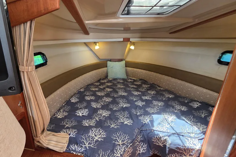 Seamore Yacht Photos Pics Cozy cabin interior of 2020 Ranger Tugs R27LE with nautical-themed bedding.