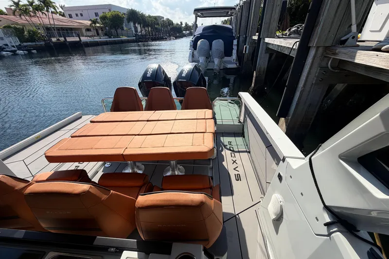  Yacht Photos Pics 2024 Saxdor 320 GTO boat with orange seating, docked by a scenic waterfront.