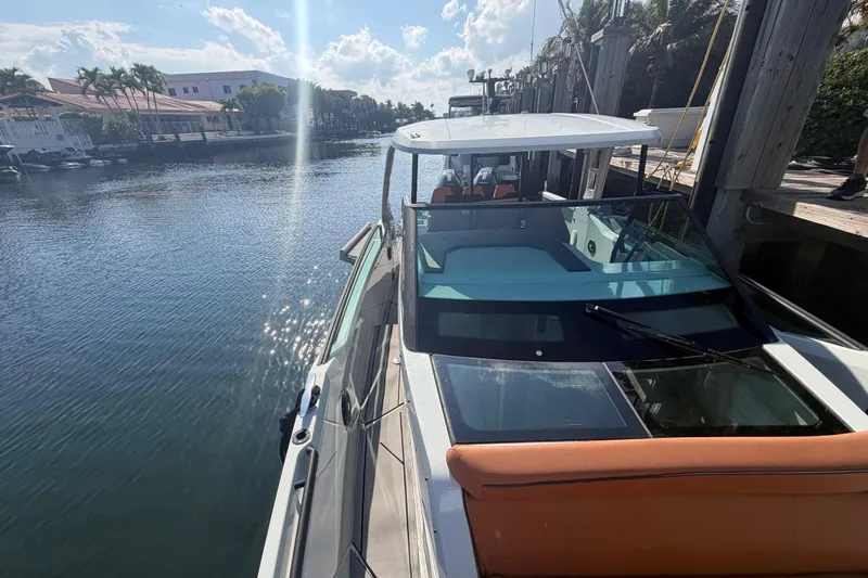  Yacht Photos Pics 2024 Saxdor 320 GTO docked by a sunny waterfront with palm trees.