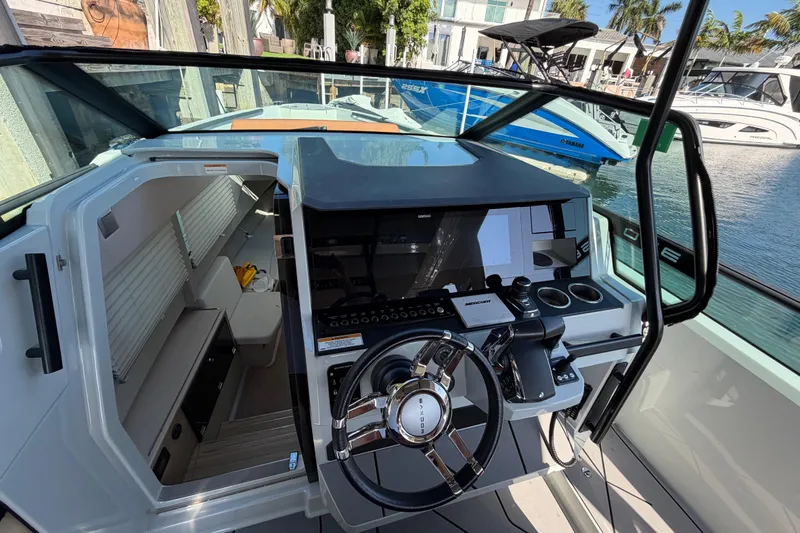  Yacht Photos Pics 2024 Saxdor 320 GTO cockpit with modern steering and navigation controls, docked at marina.
