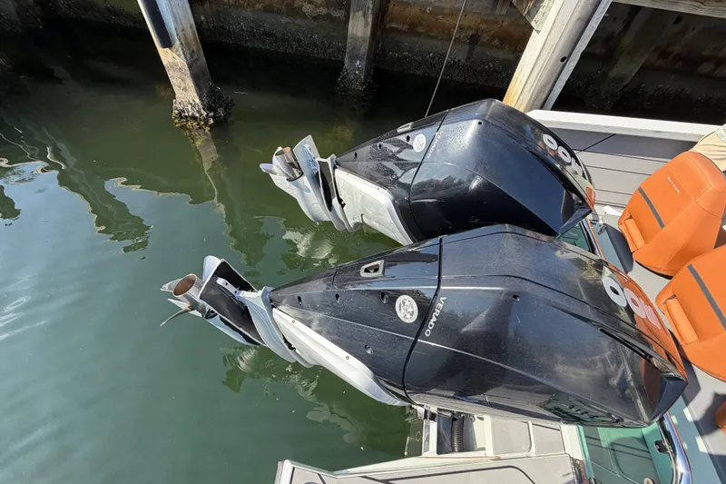  Yacht Photos Pics Twin outboard engines on a 2024 Saxdor 320 GTO boat docked by the water.
