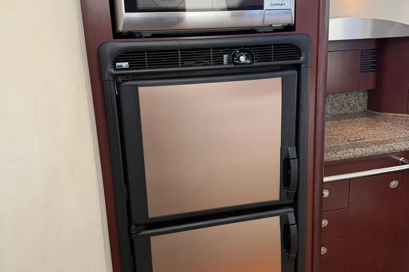 Shell’s Island II Yacht Photos Pics Stainless steel refrigerator and microwave in 2008 Sea Ray 44 Sedan Bridge yacht kitchen.