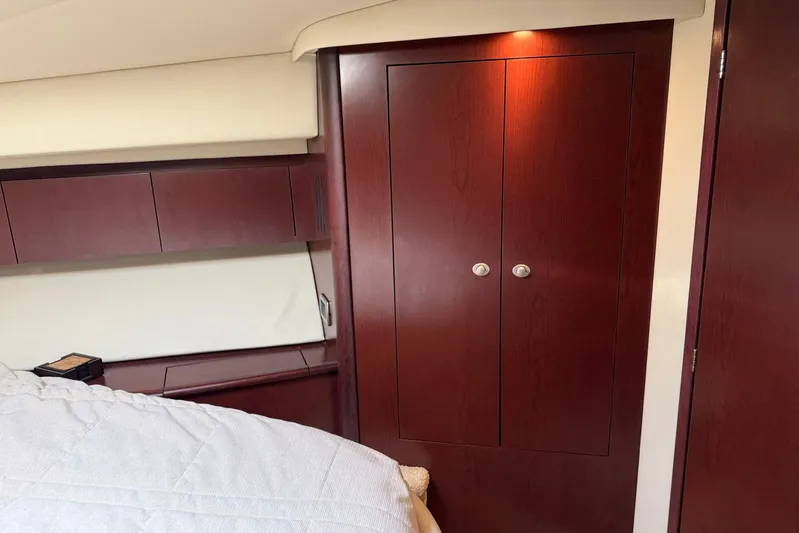 Shell’s Island II Yacht Photos Pics Interior of 2008 Sea Ray 44 Sedan Bridge with wooden cabinetry and cozy bedding.