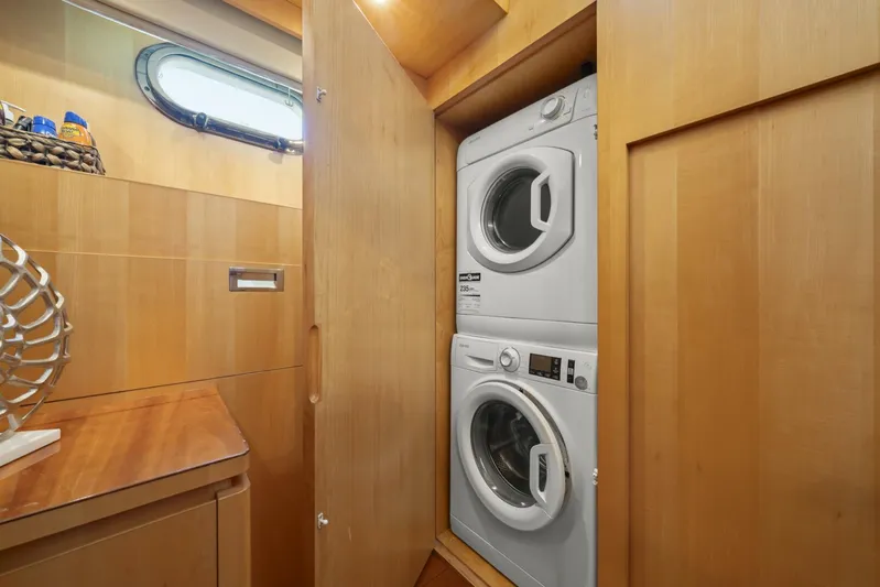 Tranquility Yacht Photos Pics Stacked washer and dryer in wooden cabinet on Horizon PC60 yacht, 2013 model.