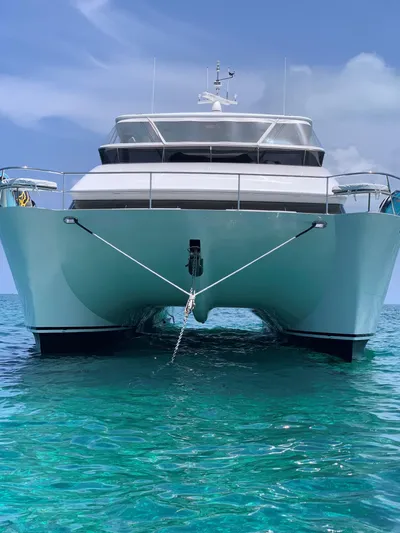 Tranquility Yacht Photos Pics Front view of a 2013 Horizon PC60 yacht anchored in clear blue water.