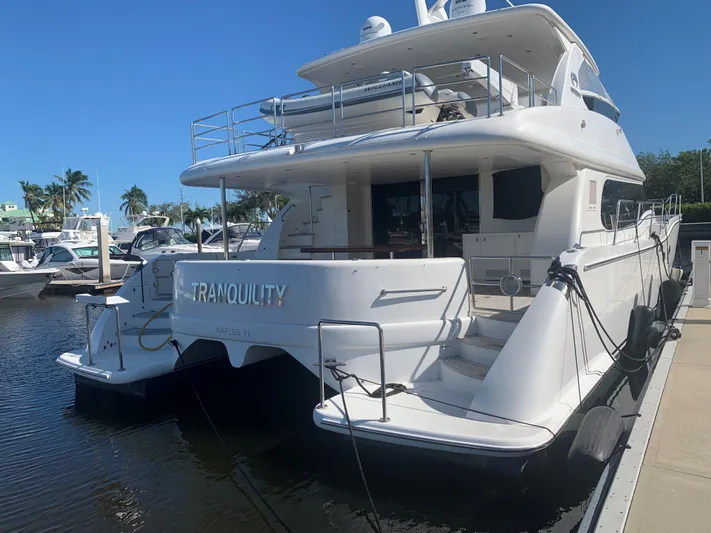 Tranquility Yacht Photos Pics Luxury Horizon PC60 yacht docked, named "Tranquility," in a sunny marina setting.