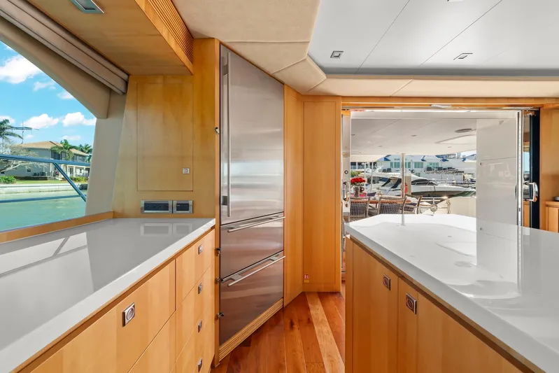 Tranquility Yacht Photos Pics Luxurious yacht interior with modern kitchen, wooden cabinetry, and outdoor view. Horizon PC60, 2013 model.