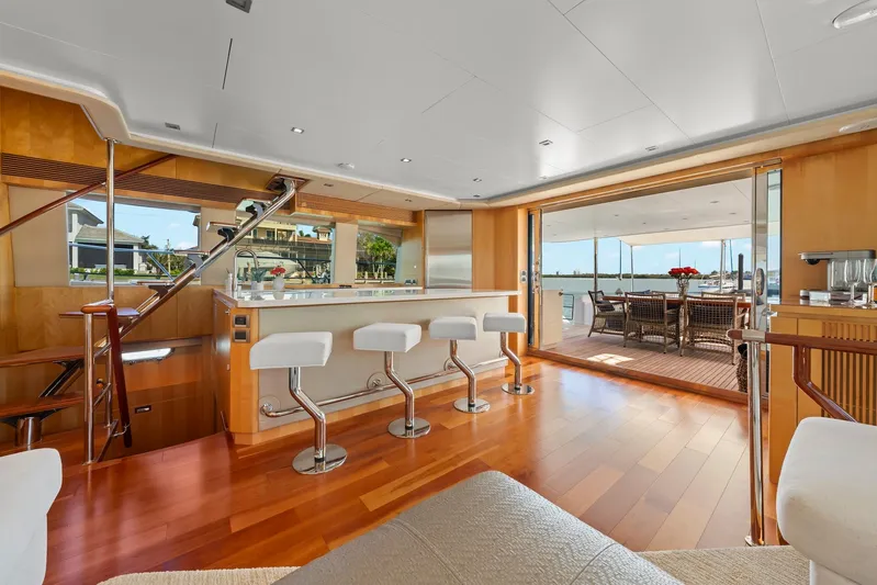 Tranquility Yacht Photos Pics Luxurious Horizon PC60 yacht interior with bar stools, wooden flooring, and outdoor dining area, 2013 model.
