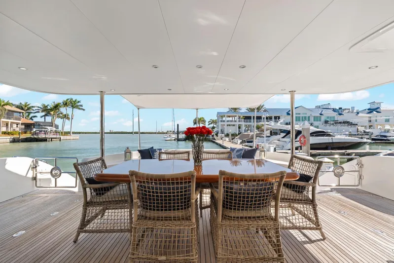 Tranquility Yacht Photos Pics Luxurious Horizon PC60 yacht deck with dining area, marina view, and elegant wicker chairs, 2013 model.