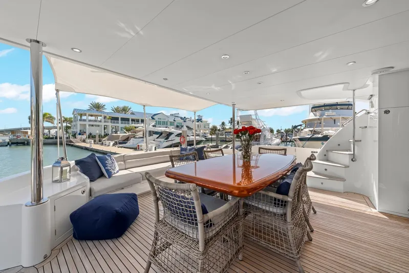 Tranquility Yacht Photos Pics Luxurious Horizon PC60 yacht deck with dining area, wicker chairs, and marina view, 2013 model.